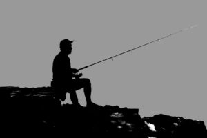 fisherman fishing off rocks